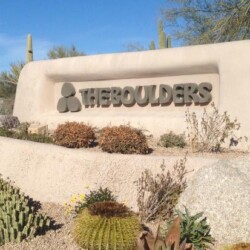 A sign that says the boulders in front of some bushes
