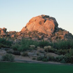 A large rock sitting on top of a hill.